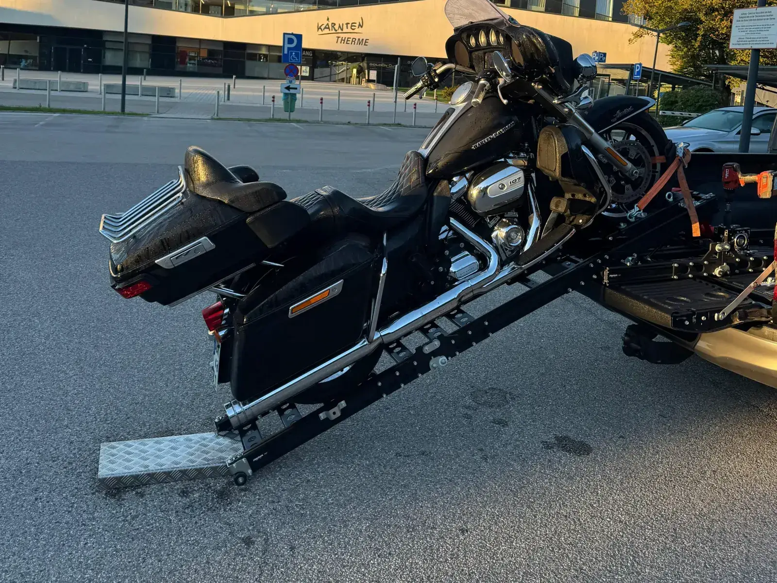 Touring motorcycle secured with straps on the lowered PiggyBack loading system.